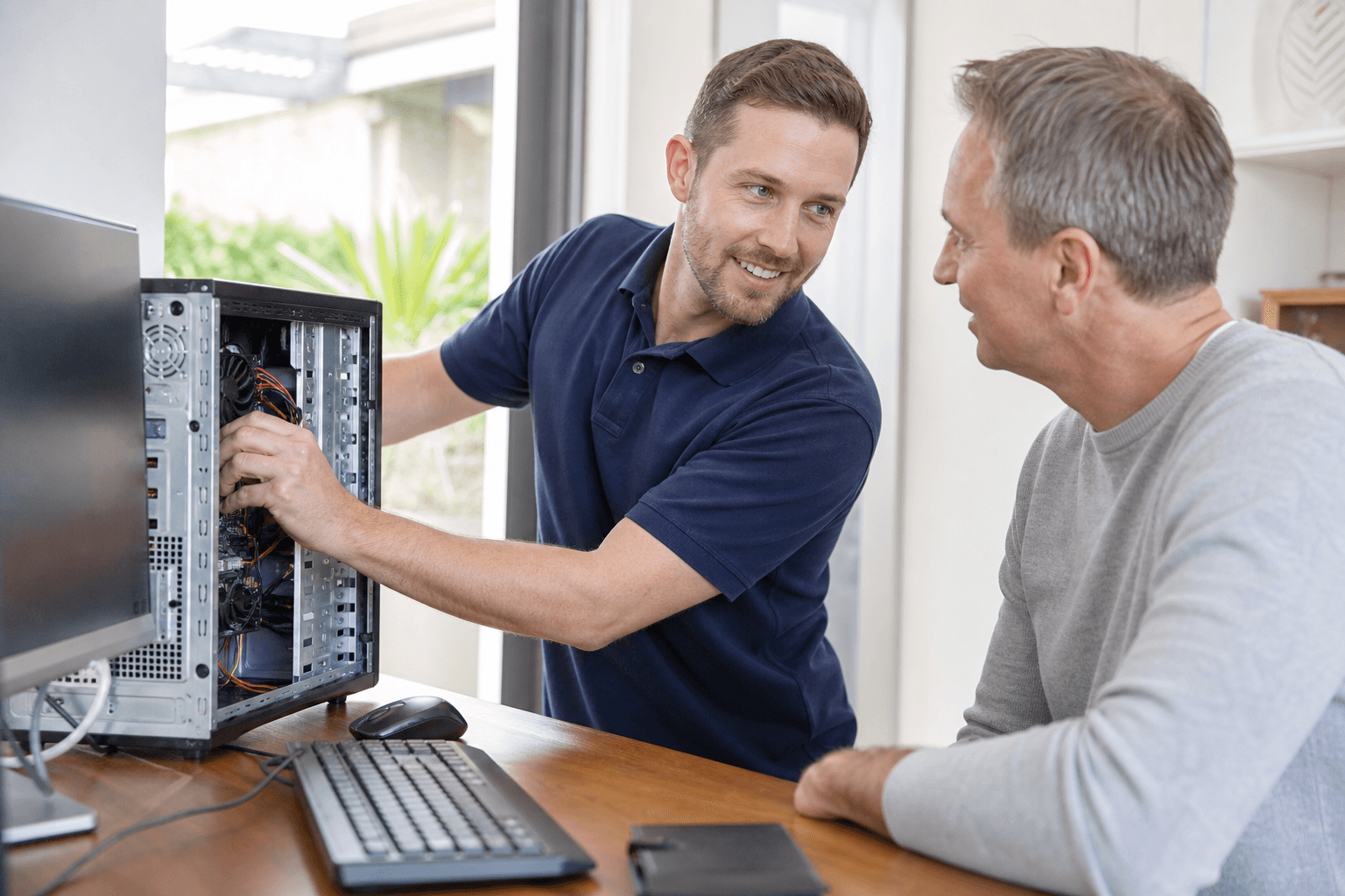 Friendly technician smiling while helping repair a computer